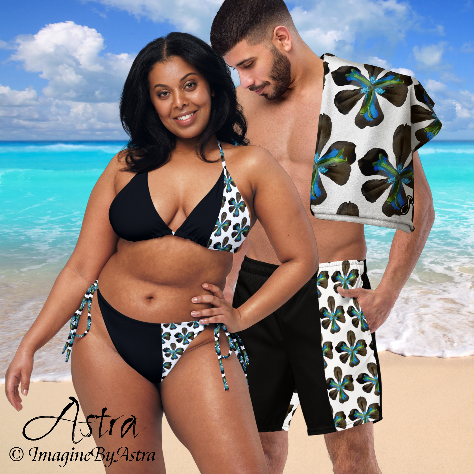 A black couple wear matching black swimsuits with white paneling with vibrant blue tropical flower print, part of the Astra swimwear lineup from Imagine By Astra.