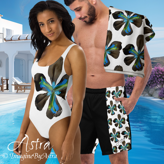 Matching couples swimsuits with blue tropical flower print. A woman wears a women’s white one-piece swimsuit next to a man wearing matching men’s swim trunks, with a resort pool in the background.