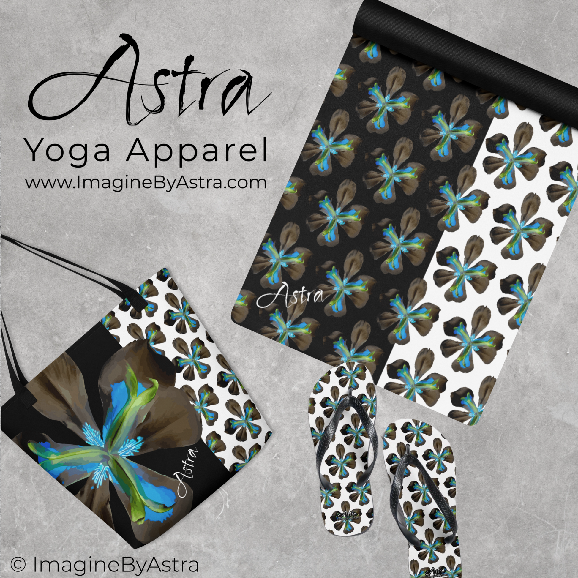 Items from The Tropical Iris Collection by Astra Activewear are laid out. A yoga mat is partially unrolled revealing a dramatic two toned black and white surface with a bright blue tropical flower print on top, the black non slip rubber back is shown on the back of the mat. The Astra Tote Bag with matching floral pattern and a pair of matching flip flops are displayed next to the mat.