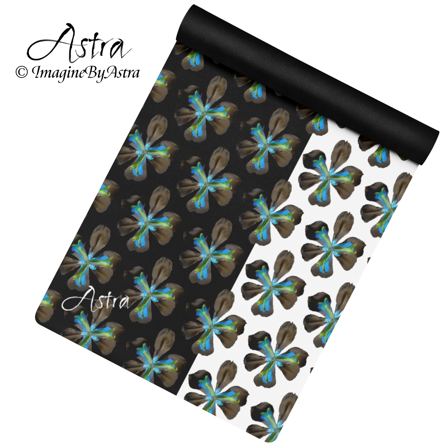 A yoga mat is partially unrolled revealing a dramatic two toned black and white surface with a bright blue tropical flower print on top, from brand, Imagine by Astra Activewear.